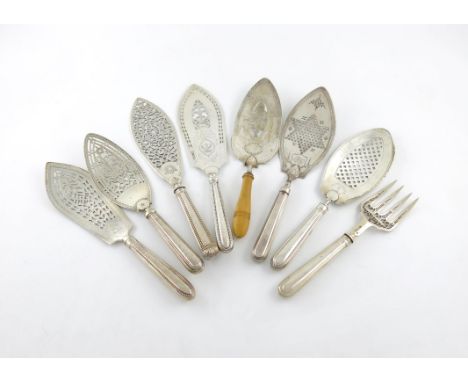 λ A collection of seven antique silver fish slices, filled tapering beaded and thread handles, the blades with pierced and en