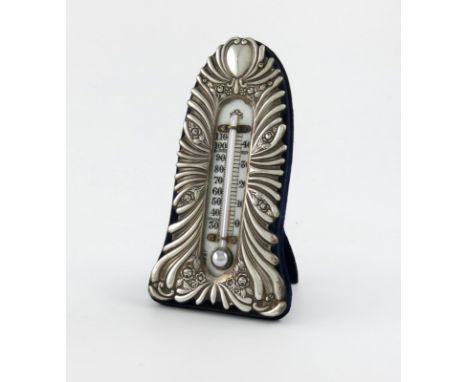 An Edwardian silver thermometer, by William Comyns, London 1902, upright arched rectangular form, fluted and foliate decorati