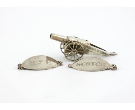 A small mixed lot of Chinese silver, comprising: a miniature model of a canon, and a pair of wine labels, incised 'SCOTCH' an