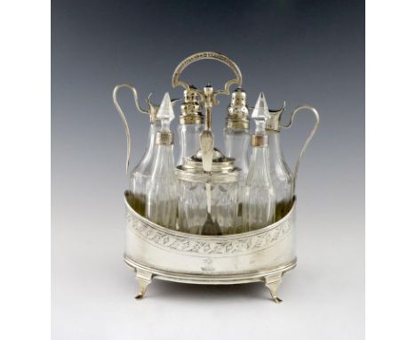 A George III silver seven bottle cruet frame, maker's mark worn, London 1793, oval form, engraved decoration, central carryin