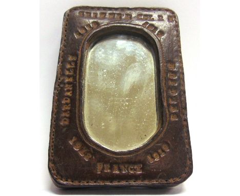 GREAT WAR - A PERSONALISED HANDMADE LEATHER FRAMED SHAVING MIRROR probably made by a harness maker, of thick leather construc