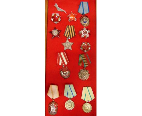 RUSSIA - NINE SOVIET ENAMEL AND METAL CAP BADGES (SATELLITE STATES)  mounted in a table-top slant fronted display cabinet.