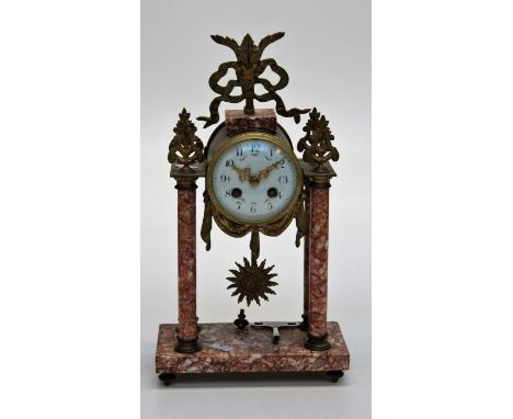 A late 19th century French gilt metal mounted and varigated rouge marble portico clock. The eight day movement striking upon 