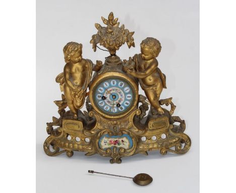 A late 19th century French gilt metal mantle clock, cast with putti, nesting chicks and rose garland around a flowering urn a