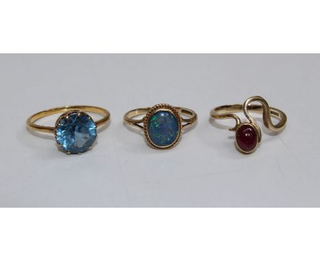 Three 9ct gold dress rings. Comprising a large blue topaz solitaire ring (approximate weight 2.9 grams, size S), an opal trip