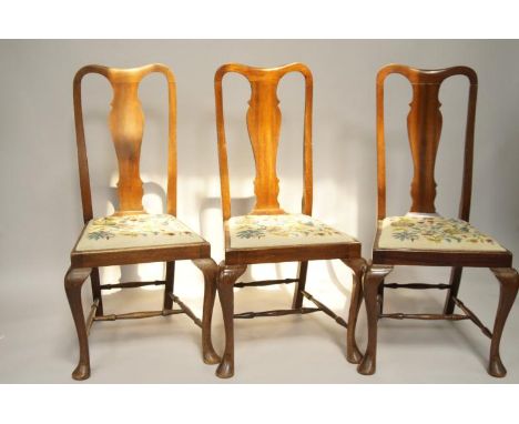   A set of six Queen Anne style mahogany dining chairs, with drop-in tapestry seats, cabriole legs and H-stretchers.