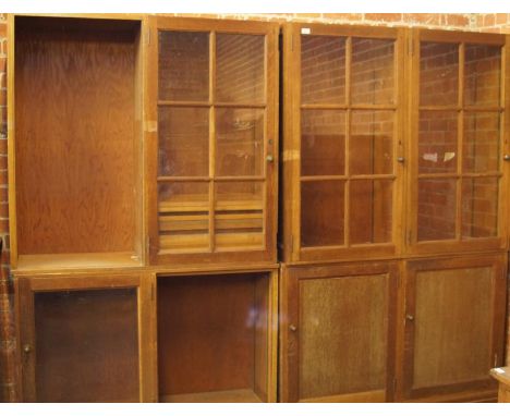 Two mid 20thC light oak glazed bookcases, with sectional bases and adjustable shelves, (AF).