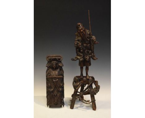 Oriental wooden carving of a fisherman standing on a naturalistic tripod base, together with an antique carved oak monopodia 