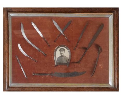 Framed montage comprising a vintage military photographic portrait with horseshoe surround and assorted miniature model steel