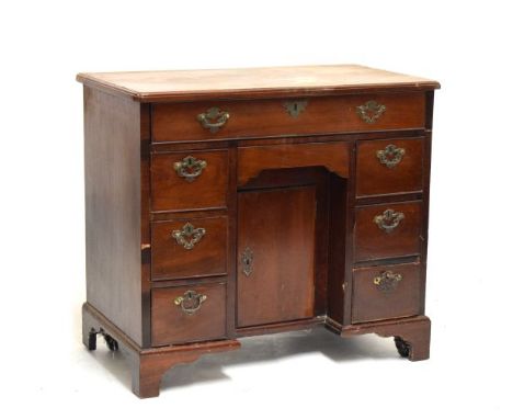 George III mahogany kneehole desk fitted eight drawers, cupboard to the kneehole and standing on bracket feet  