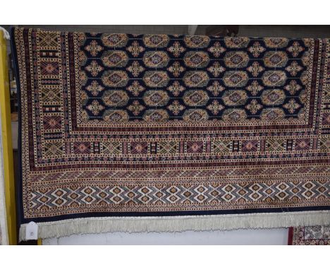 A Bokhara carpet with tasselled borders and blue ground. (230 x 160cm) 