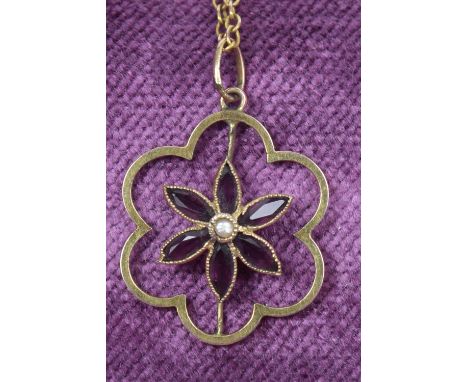 An early 20th century purple paste and split pearl pendantThe split pearl and marquise shape purple paste floral cluster with