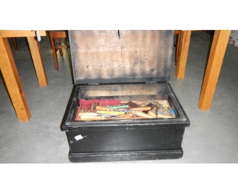 A black wooden tool box containing large quantity of wood working tools, wooden and metal planers etc