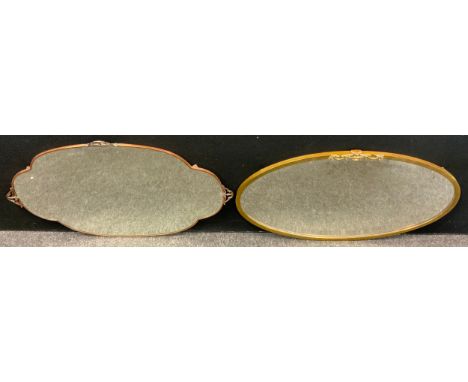 An early 20th century Arts and Crafts style shaped copper wall mirror, bevelled glass;  another two wall mirrors, (3) 