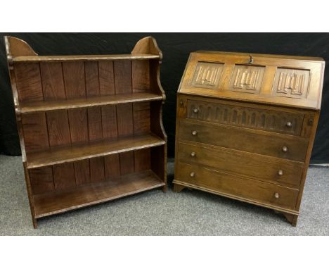 A Priory style oak bureau, having a carved linen-fold fall door above four long drawers, bracket feet, 92cm tall x 76cm wide 