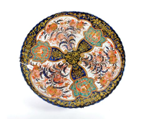 An Imari Porcelain Large Dish, Meiji period, of fluted circular form, typically painted with fan shaped panels of foliage on 