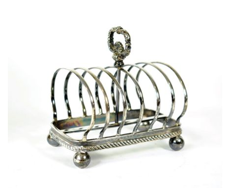 A George V Silver Toast Rack, George Howson, London 1910, with central foliate handle, gadroon border and on ball feet, 12.5c