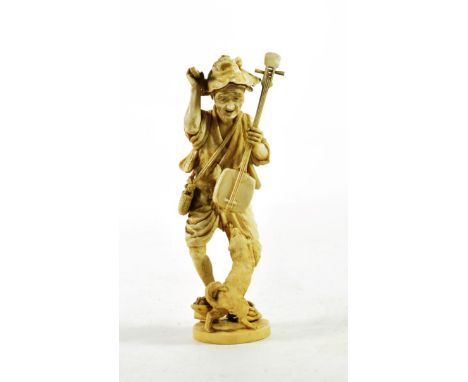 A Japanese Ivory Okimono, Meiji period, as an old a man holding a Biwa and plectrum, a dog at his feet on an oval base, signe