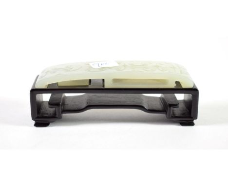 A Chinese Jade Belt Buckle, of traditional form carved with formal scrolls, 10cm long