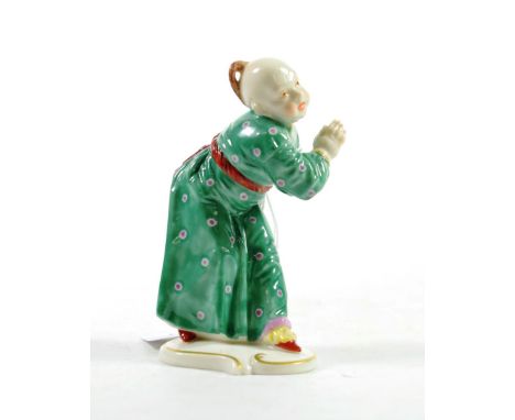 A Nymphenburg Porcelain Figure, 20th century, after Franz Anton Bustelli, as a Chinese boy in a flowing green robe on a scrol