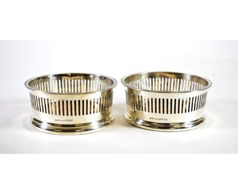 A Pair of George V Silver Wine Coasters, Asprey &amp; Co, Birmingham 1915, with reeded rim and pierced sides, 13cm diameter (