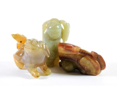 A Chinese Jade Figure of a Boy, holding a tree branch, 6cm; An Agate Figure of a Lion Dog, 5cm; and A Jade Type Figure of a C