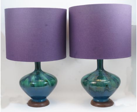 A pair of Italian ceramic table lamps, 20th century, of bottle shape with mottled green and turquoise glaze, atop turned wood