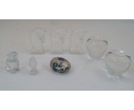 A group of clear glass paperweights, 20th century, to include two modelled as apples, each 10cm high, three modelled as horse