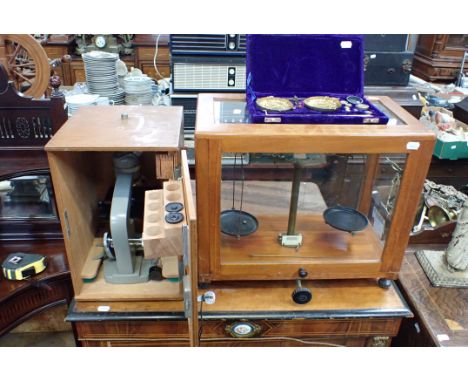 A SET OF GLASS-CASED SCIENTIFIC SCALES with another set of scales and a microscope 