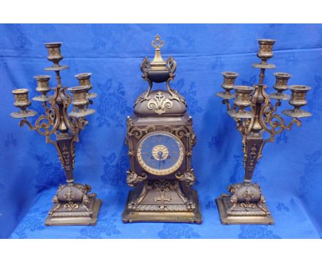 A PATINATED BRASS CLOCK GARNITURE the clock case in French Renaissance style 45cm high, flanked by candelabra, with countwhee