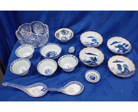 A SET OF FOUR BLUE AND WHITE CHINESE TEA BOWLS decorated with rice pattern and a dragon chasing a pearl wo the interior toget