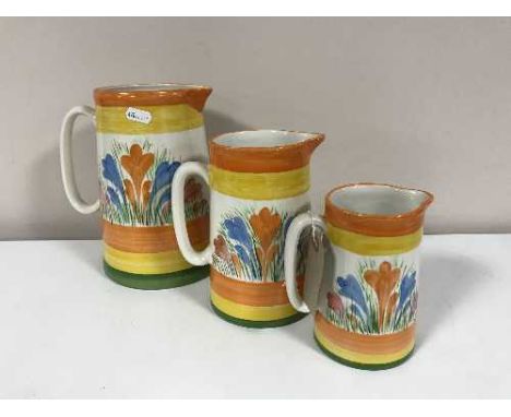 A set of three graduated jugs in Clarice Cliff style