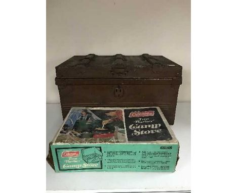 A boxed Coleman camp stove, tin trunk of board games, glass water jug etc 