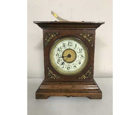 An early 20th century walnut cased musical mantel clock with enamel dial