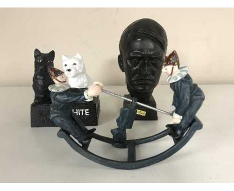 A cast metal clowns on rocking horse figure together with a Black and White Scotch figure and metal bust of Hitler