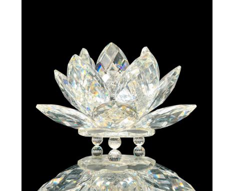 Crystal water lily with faceted petals, center opening for a candlestick, and spherical feet applied to base. Swarovski acid 