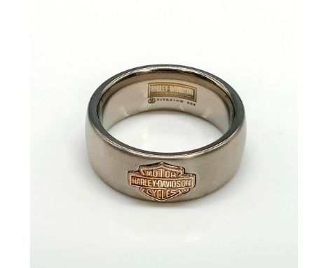 Copper tone sterling silver Harley Davidson logo on a silver tone titanium band with satin finish. Titanium and 925 stamped i