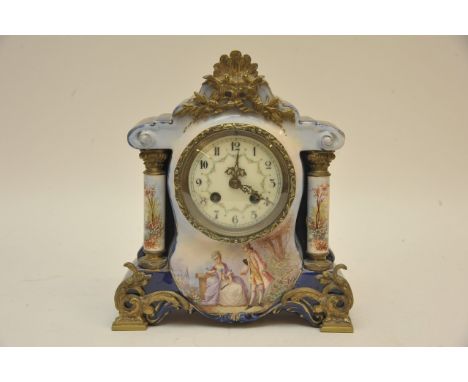 An Edwardian porcelain mantel clock of classical style, the dial with Arabic numerals, the case with a courting couple scene 