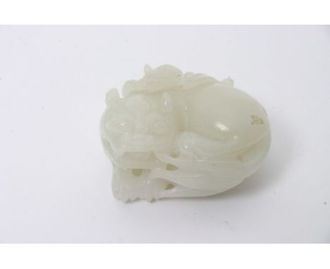 A Chinese white jade carving in the form of a reclining mythical beast with a Fu bat upon its back. Length: 4cm approximately