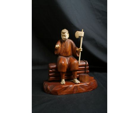 A ivory and wood Okimono figure of a working man with axe. Measures 18 cms