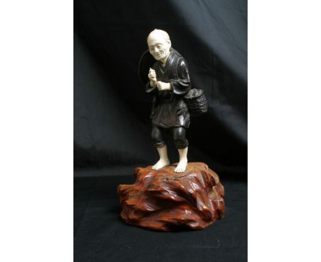 A quality Japanese bronze and ivory figure man with an opium pipe on a naturalist base. 25 cm