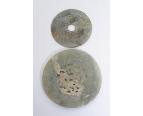 A Chinese carved and pierced hard stone disc, possibly jade, with raised mythical beasts, diameter: 12cm approximately, toget