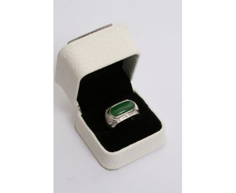 A 18ct white gold ring inset with jade stone surrounded by diamonds with testing certificate.