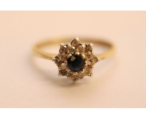 A ladies 9ct yellow gold ring set with a central sapphire with diamond surround