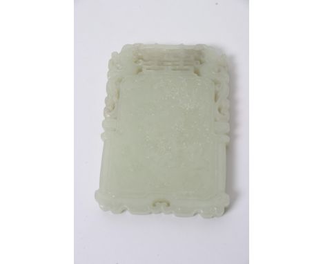 A Chinese green hardstone tablet with pierced rim and raised Chinese script and figures, possibly Jade. Length: 7.5cm approxi