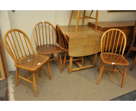 An Ercol drop leaf table with a set of five stick back chairs