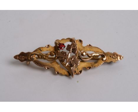 A 9ct gold brooch of foliate design inset with a ruby 