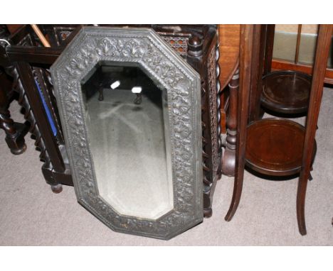 A bevelled edge mirror with chamfered corners and embossed brass surround