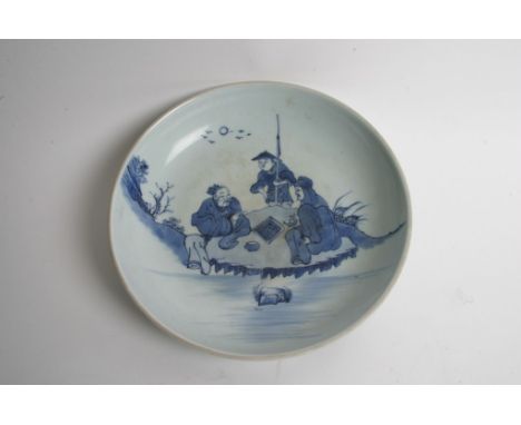 A Chinese blue and white plate decorated with three figures playing a game. Diameter: 29cm approximately