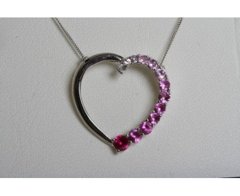 A 9ct white gold heart pendant and chain of modern design, set with ruby coloured stones